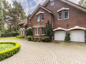 Stone driveway to english red brick residence in the forest